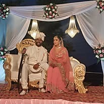 Wedding couple seated on a decorated stage