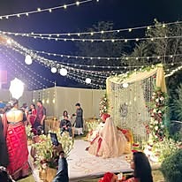 Bride seated beneath string lights at a wedding ceremony