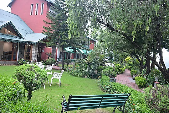 Lawn with a green bench and cottages behind