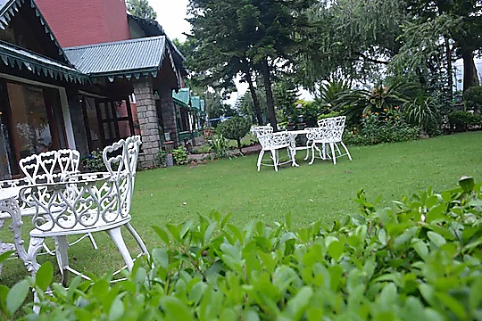 White garden chairs beside the resort cottages