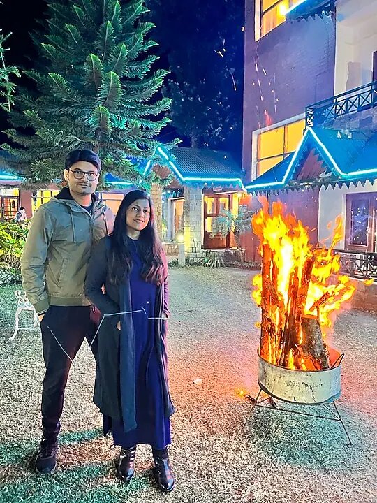 Couple standing by an evening bonfire